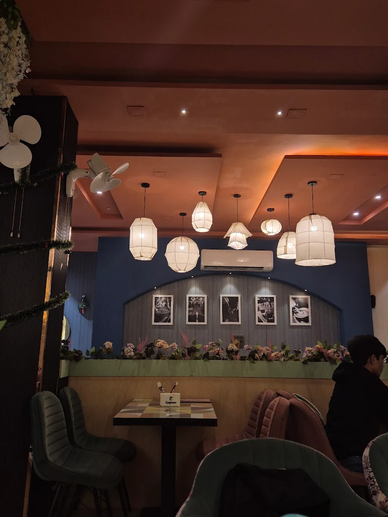 A cozy corner of the cafe with warm lighting and plush seating